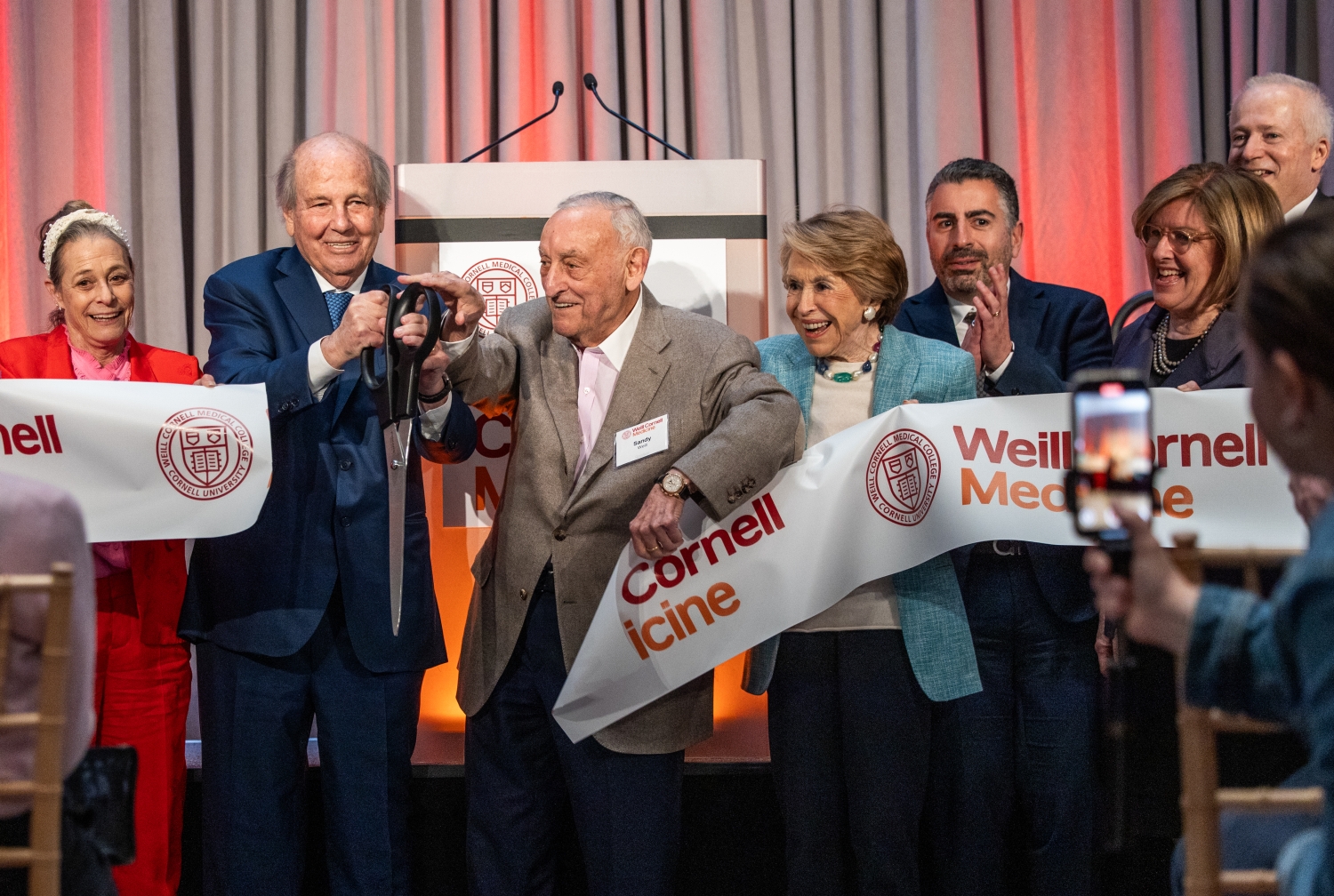 A group of people cutting a ceremonial ribbon