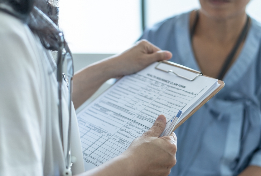 a doctor reviewing medical paperwork to a patient