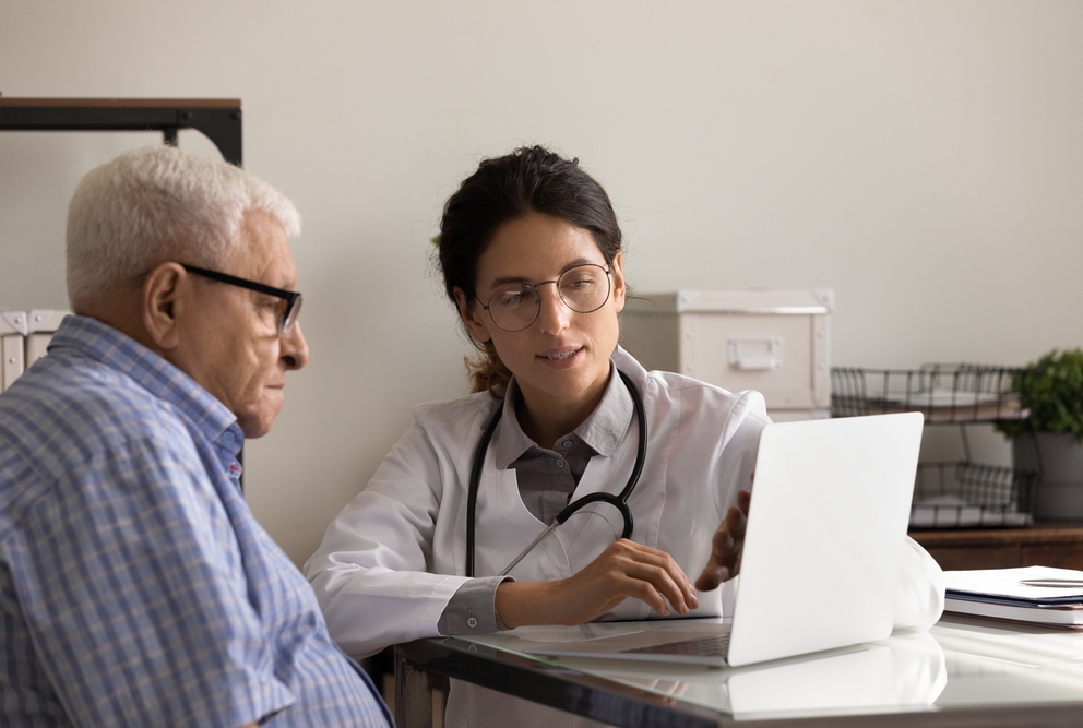 a doctor showing an older male patient his medical results