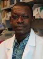 A man posing for a photo in a white coat