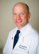 a man in a white coat posing for a photo