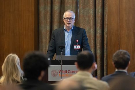 Man at a podium with audience in the background