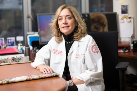 a woman in a white coat posing for a photo
