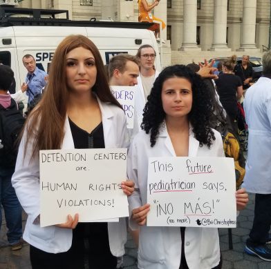 two woman holding up signs in protest