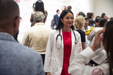 A woman wearing a red dress and white medical coat